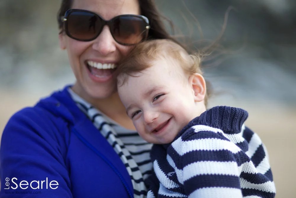 Mother and her toddler son laughing together outdoors during a family photo session in Cornwall