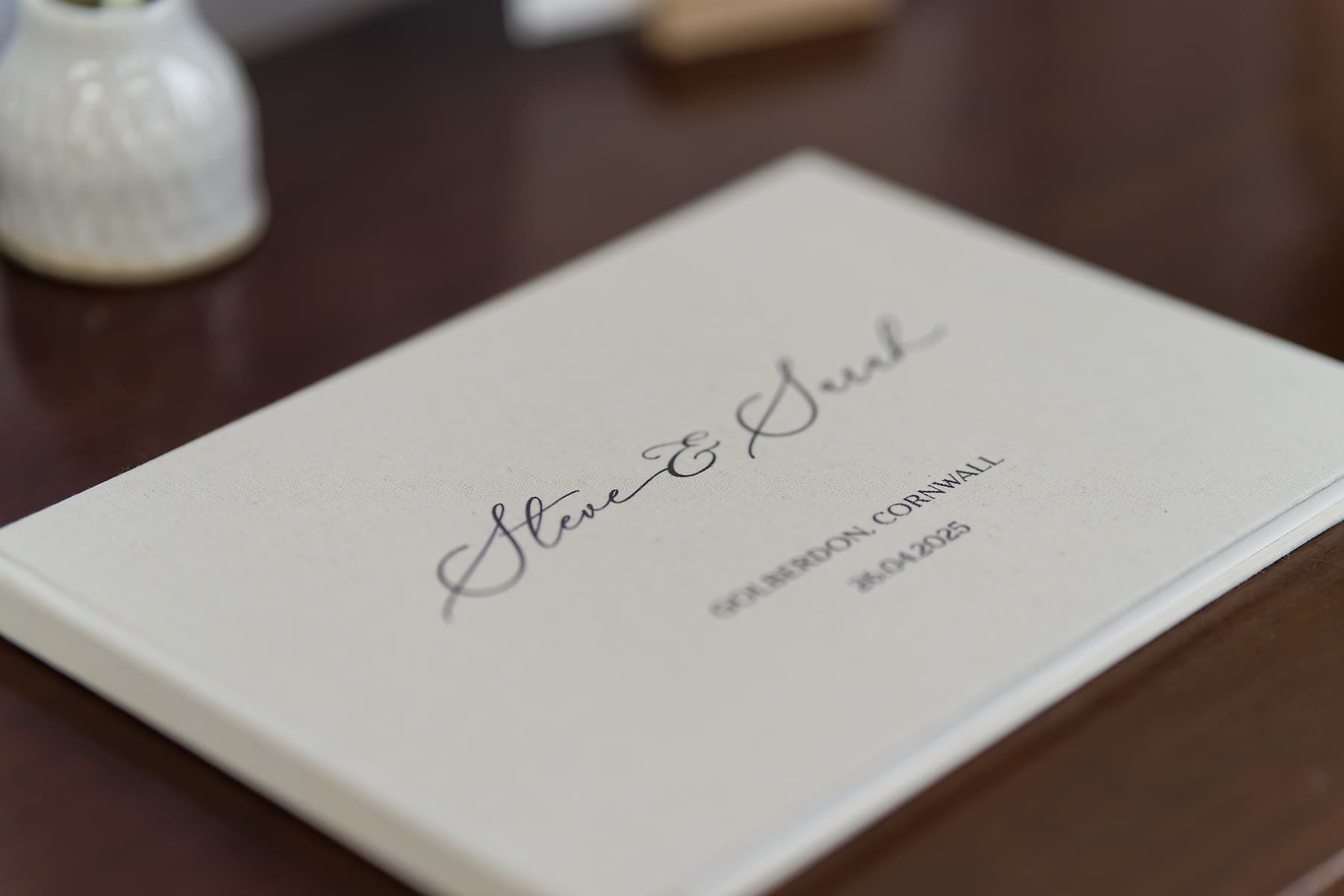 Personalised Lee Searle wedding album for a Cornwall wedding on a wooden table