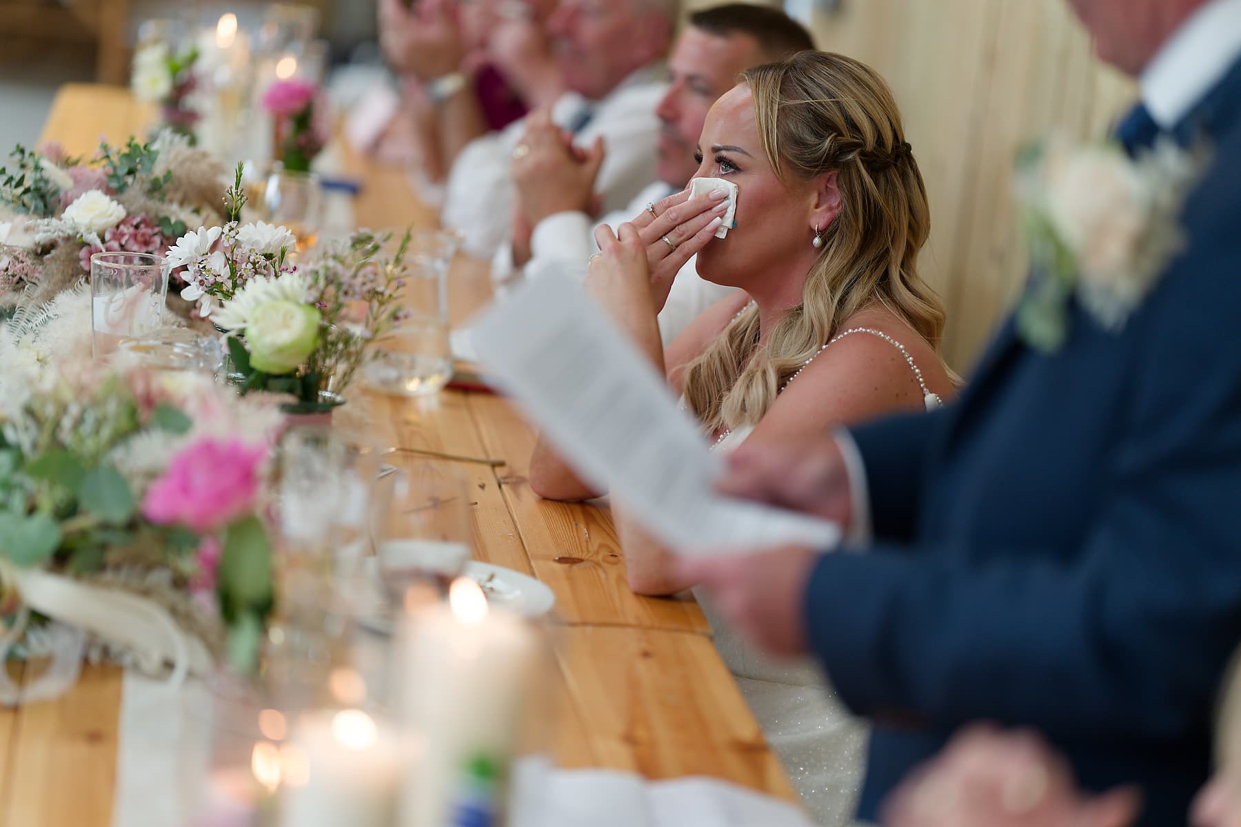 Bride wiping away tears during speeches at her Cornwall wedding reception